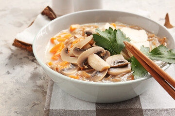 Bowl with Thai chicken noodle soup on grunge background