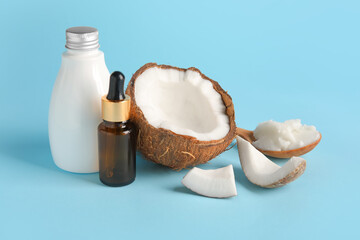 Bottles with coconut oil on color background
