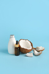 Bottles with coconut oil on color background