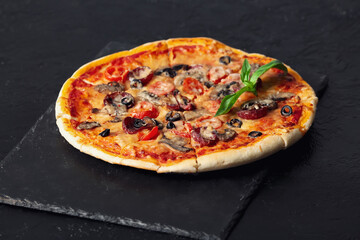 Board with tasty pizza on dark background