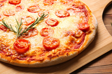 Board with tasty pizza on wooden background, closeup