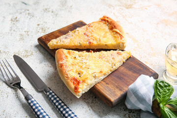 Board with pieces of tasty pizza on light background