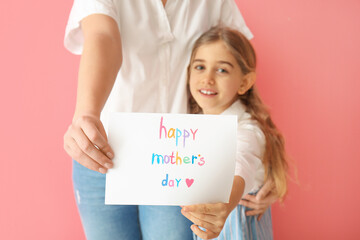 Little girl and her mom with greeting card for Mother's Day on color background, closeup