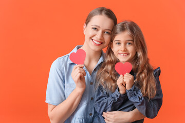 Happy woman and her little daughter with red hearts on color background