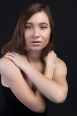 Fototapeta premium Young brown-haired woman, studio photo on a black background