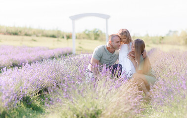 Happy caucasian family resting on lavander field, hugging each other , spending time together