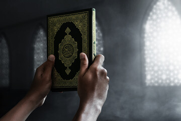Religious muslim man holding holy quran - 423649487