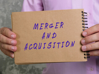 Financial concept about MERGER AND ACQUISITION with phrase on the sheet.