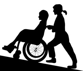 坂道で車椅子を押す女性のシルエット