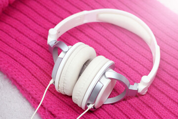 White elegant headphones on a pink scarf