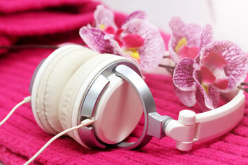 Obraz na płótnie Canvas White elegant headphones, orchid on a pink scarf