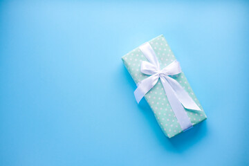 Present on blue background.women day. Mother day .Gift with white ribbon.