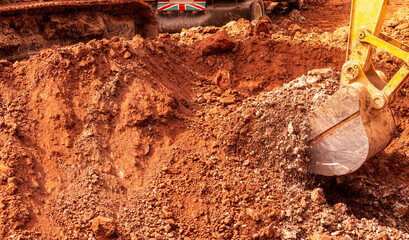 Backhoe digging soil at construction site. Bucket of backhoe digging soil. Crawler excavator...