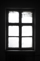 Textured silhouette of an old wooden window in dark abandoned interior.
