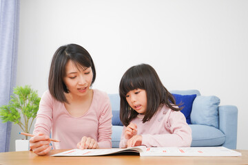 お家でお勉強をする女の子とお母さん
