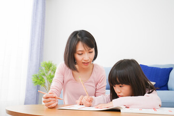 Fototapeta na wymiar お家でお勉強をする女の子とお母さん