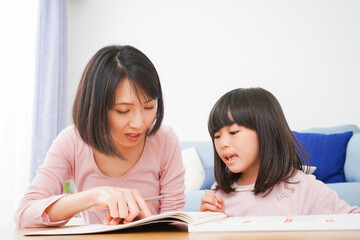 お家でお勉強をする女の子とお母さん