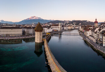 Fototapeta premium Sunrise over the famous Chapel's bridge on the Reuss river in Lucerne old town, Switzerland