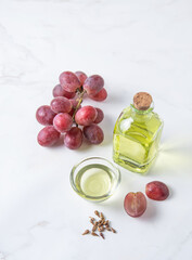Natural vegetable oil from grape seeds in a clear bottle on the kitchen table. Dietary healthy food