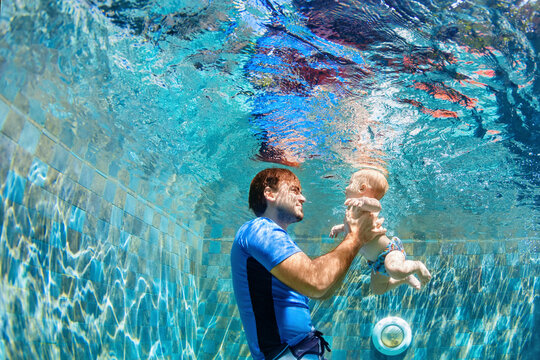 Happy people dive underwater with fun. Funny photo of father, child in aqua park swimming pool. Family lifestyle, kids water sports activity, swimming lesson with parents on summer holiday
