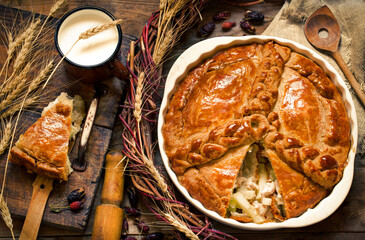 meat pie with vegetables with a golden crust in a rustic style on a wooden board
