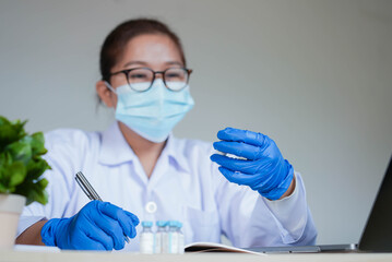 close up young asian scientist woman hold vaccine tester to diagnose  about pharmaceutical...