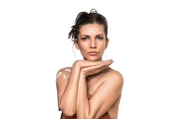 Obraz premium Studio portrait of a beautiful adult woman with brown hair gathered in a tousled bun. Folded palms. Pretty girl artist model with perfect fresh clean skin. She is wearing an artist's leather apron. 