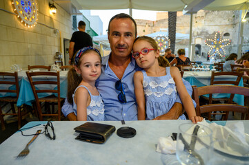 Fototapeta na wymiar Papà con le sue figlie gemelle di sei anni.