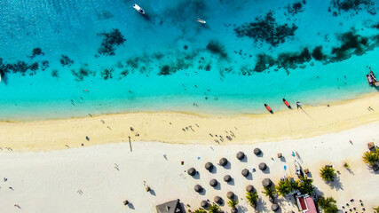A bird's-eye view of the white sand beach and turquoise waters of the Indian Ocean.