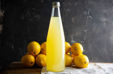 Traditional Italian lemon beverage limoncello in bottle on the dark rustic background. Selective...