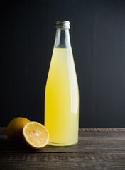 Traditional Italian lemon beverage limoncello in bottle on the dark rustic background. Selective...