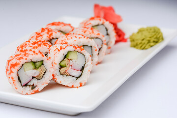 Sushi set with caviar on the white plate over white background. Traditional Japanese cuisine concept.