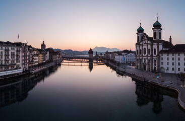 Sunset over the Lucerne old town and the Reuss river with its famous Chapel wooden bridge in Central Switzerland