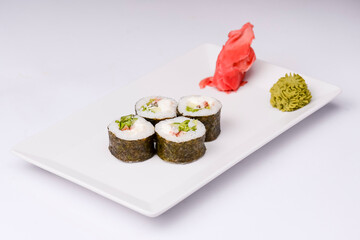 Sushi small set served on a white plate over white background. Traditional Asian Japanese cuisine concept.