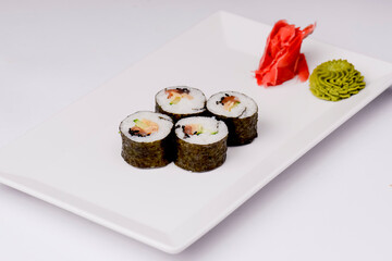 Sushi small set served on a white plate over white background. Traditional Asian Japanese cuisine concept.