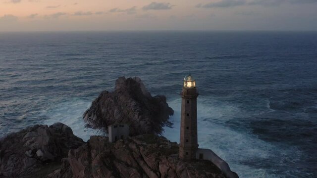 Lit lighthouse at dusk in Cape Vilan Galicia Spain Aerial view