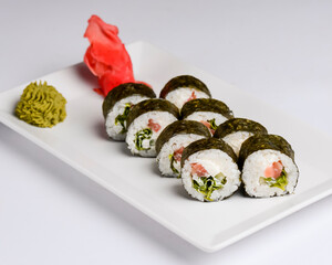 Sushi small set served on a white plate over white background. Traditional Asian Japanese cuisine concept.