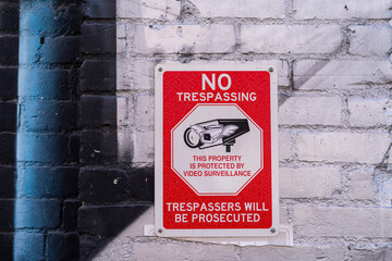 Video surveillance warning sign on a brick wall