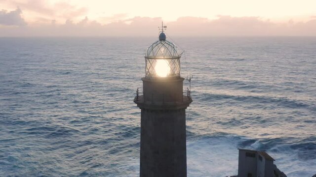 Lit lighthouse at dusk in Cape Vilan Galicia Spain Aerial view