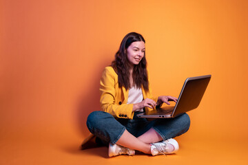 Naklejka premium freelancer at a laptop, a young specialist working remotely. A young woman in modern-style clothing