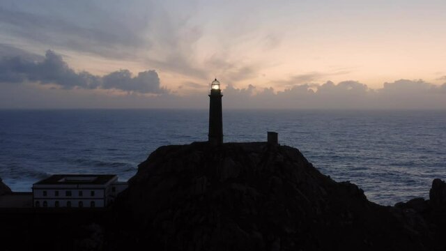 Lit lighthouse at dusk in Cape Vilan Galicia Spain Aerial view