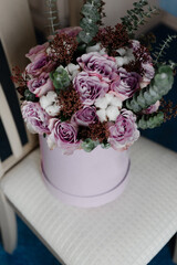 the bride's lovely wedding bouquet is in a cardboard stand. bouquet made by florists. a bouquet of flowers standing on a chair. festive flowers of the bride.