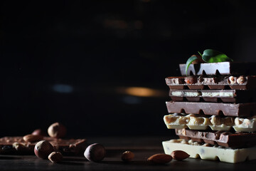 A bar of milk chocolate. Homemade milk chocolate with almonds and dried strawberries. Pieces of milk chocolate. Set of milk chocolate with tea.