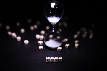 Sand running through the bulbs of an hourglass measuring the passing time in a countdown to a...