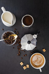 Fototapeta na wymiar Still life with moka pot, coffee beans, milk, sugar and fresh hot espresso