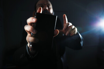A bearded man in a suit holds an object in his hand. Concept of time and ideas. Aspiration and development.