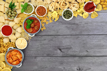 Italian healthy food border with pasta collection and ingredients high in antioxidants, anthocyanins, fibre, lycopene & protein. Flat lay, top view on rustic silver wood background.