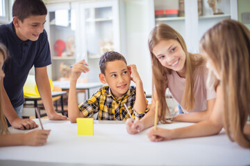 Great teamwork.  Teenagers students sitting in the classroom and talking.