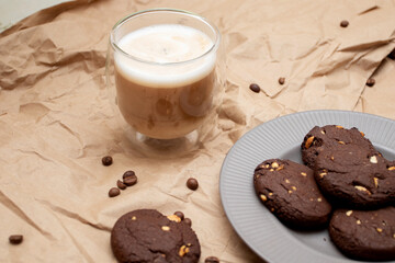 Chocolate chip cookies and coffee in double glass on craft paper