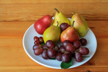 Pears of different varieties and purple grapes.